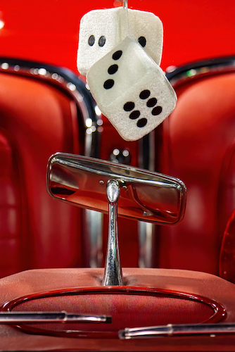 Close up photo of dice in a vintage car windshield