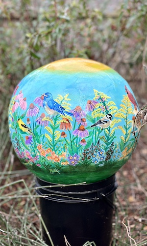 cement sphere painted with bird designs