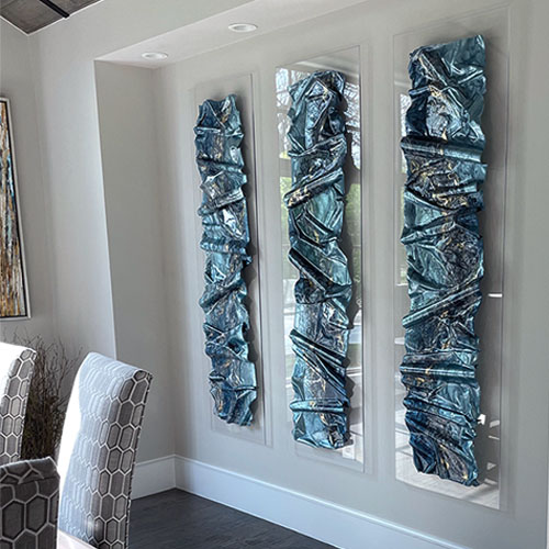 sculpted resin triptych wall art installed in room