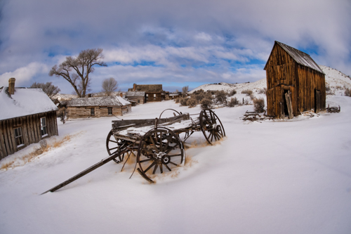 Photograph of an old wagon in snow in a Western ghost town