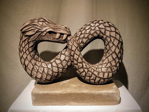 limestone sculpture of a twisted serpent