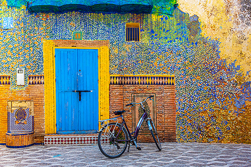 photo of a bicycle on a Morrocan street near a decorated building