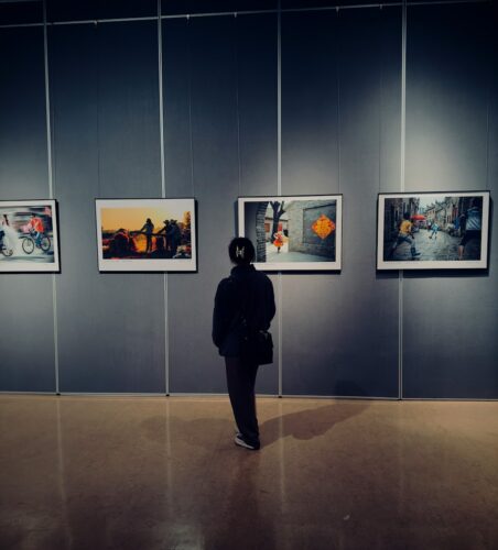 a woman standing in front of a wall with pictures on it